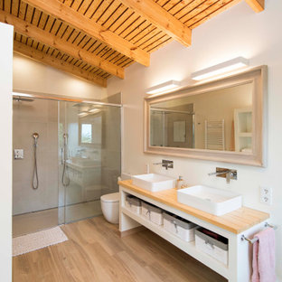 Diseño de cuarto de baño madera, a medida y doble, mediterráneo, madera, con armarios abiertos, puertas de armario blancas, ducha a ras de suelo, baldosas y/o azulejos grises, paredes blancas, suelo de madera clara, lavabo sobreencimera, encimera de madera, suelo beige, ducha con puerta corredera, encimeras beige y madera