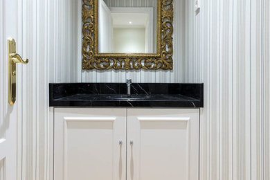 Diseño de cuarto de baño tradicional renovado pequeño con baldosas y/o azulejos negros, suelo de madera clara, aseo y ducha, encimera de mármol y suelo beige