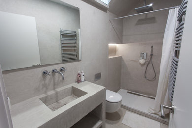 他の地域にあるお手頃価格の中くらいなラスティックスタイルのおしゃれなバスルーム (浴槽なし) (オープンシェルフ、アルコーブ型シャワー、壁掛け式トイレ、グレーの壁、一体型シンク) の写真