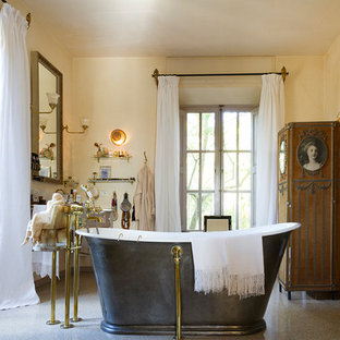 Ejemplo de cuarto de baño principal, tradicional, con bañera exenta, armarios tipo mueble, puertas de armario de madera oscura, paredes beige y suelo beige