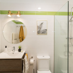 Imagen de cuarto de baño tropical con ducha esquinera, sanitario de una pieza, baldosas y/o azulejos verdes, baldosas y/o azulejos blancos, paredes blancas, lavabo tipo consola y ducha abierta