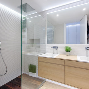 Imagen de cuarto de baño con ducha, nórdico, pequeño, con armarios con paneles lisos, puertas de armario de madera clara, ducha empotrada, paredes blancas, lavabo integrado, encimera de madera, suelo de madera clara, suelo beige, ducha abierta y encimeras beige