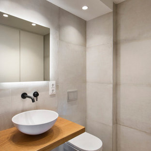 Diseño de cuarto de baño moderno con baldosas y/o azulejos beige, paredes beige, suelo de madera en tonos medios, lavabo sobreencimera, encimera de madera, suelo marrón y encimeras marrones