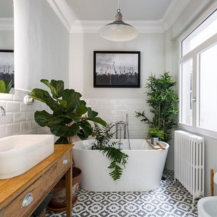 Foto de cuarto de baño principal, tradicional renovado, de tamaño medio, con armarios tipo mueble, puertas de armario de madera oscura, bañera exenta, paredes blancas, suelo de baldosas de cerámica, lavabo sobreencimera, encimera de madera, suelo multicolor, baldosas y/o azulejos blancos y baldosas y/o azulejos de cemento