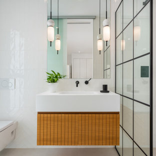Diseño de cuarto de baño con ducha, único y flotante, actual, de tamaño medio, con puertas de armario de madera oscura, ducha a ras de suelo, sanitario de pared, baldosas y/o azulejos blancos, suelo beige, ducha abierta y encimeras blancas