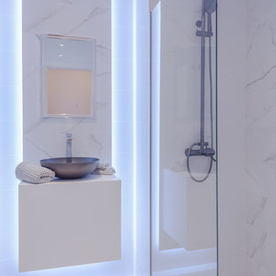 Foto de cuarto de baño actual con armarios con paneles lisos, puertas de armario blancas, ducha a ras de suelo, paredes blancas, lavabo sobreencimera, suelo blanco, ducha abierta y encimeras blancas
