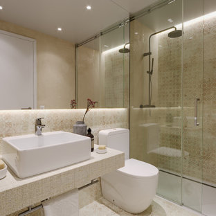 Modelo de cuarto de baño con ducha, único y flotante, actual, de tamaño medio, con puertas de armario beige, ducha empotrada, sanitario de una pieza, lavabo sobreencimera, suelo beige, ducha con puerta corredera y encimeras beige