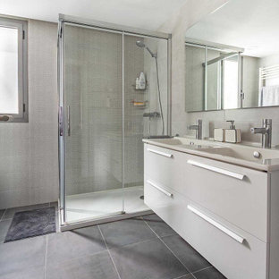 Imagen de cuarto de baño con ducha, actual, grande, con armarios con paneles lisos, puertas de armario blancas, ducha esquinera, baldosas y/o azulejos grises, baldosas y/o azulejos de porcelana, suelo de baldosas de porcelana, lavabo integrado, suelo gris, ducha con puerta con bisagras y encimeras beige