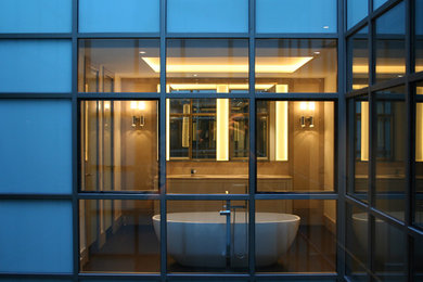 Imagen de cuarto de baño principal contemporáneo de tamaño medio con armarios con paneles lisos, puertas de armario blancas, bañera exenta, combinación de ducha y bañera, paredes beige y lavabo bajoencimera