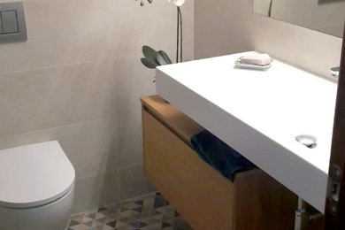 Diseño de cuarto de baño principal contemporáneo pequeño sin sin inodoro con sanitario de pared, baldosas y/o azulejos multicolor, baldosas y/o azulejos en mosaico, paredes beige, suelo con mosaicos de baldosas, lavabo suspendido, suelo multicolor, ducha con puerta corredera y encimeras blancas