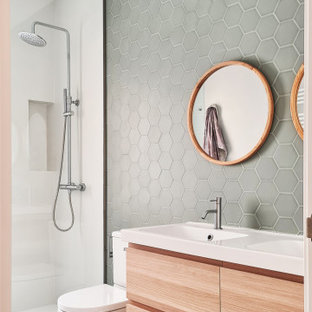 Foto de cuarto de baño actual con armarios con paneles lisos, puertas de armario de madera clara, ducha empotrada, baldosas y/o azulejos grises, lavabo integrado, suelo blanco y encimeras blancas