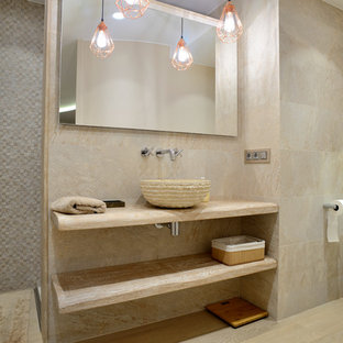 Modelo de cuarto de baño actual con armarios abiertos, ducha empotrada, sanitario de pared, baldosas y/o azulejos beige, paredes beige, lavabo sobreencimera, encimera de madera, suelo beige, ducha abierta y encimeras beige