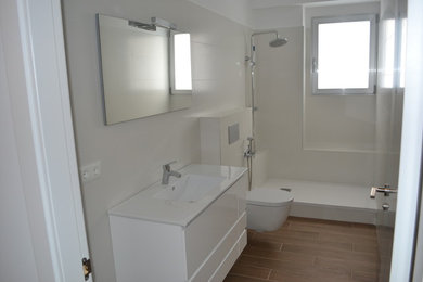 Diseño de cuarto de baño contemporáneo de tamaño medio con armarios con paneles lisos, puertas de armario blancas, ducha abierta, sanitario de pared, aseo y ducha y lavabo integrado