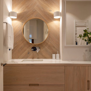 Foto de cuarto de baño contemporáneo, grande, con puertas de armario de madera oscura, encimeras blancas, baldosas y/o azulejos beige, baldosas y/o azulejos de porcelana, paredes beige, suelo laminado, lavabo bajoencimera, encimera de mármol, suelo marrón y armarios con paneles lisos