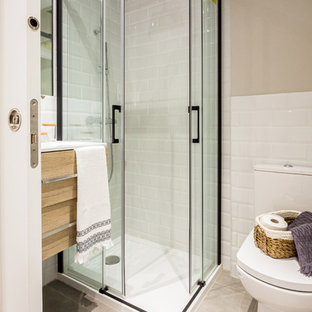 Foto de cuarto de baño con ducha, contemporáneo, pequeño, con puertas de armario de madera clara, ducha esquinera, baldosas y/o azulejos blancos, baldosas y/o azulejos de cerámica, armarios con paneles lisos, sanitario de una pieza, paredes beige, lavabo tipo consola, suelo beige, ducha con puerta corredera y encimeras blancas
