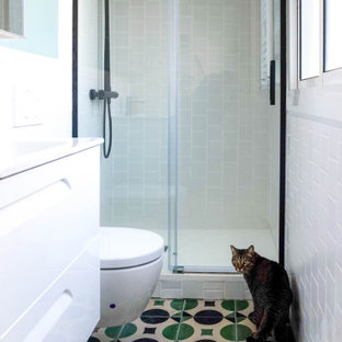 Esempio di una piccola stanza da bagno padronale scandinava con ante lisce, ante bianche, doccia alcova, WC sospeso, piastrelle bianche, piastrelle in ceramica, pareti bianche, pavimento in cementine, lavabo integrato, top in superficie solida, pavimento multicolore, porta doccia scorrevole, top bianco, toilette, un lavabo e mobile bagno incassato