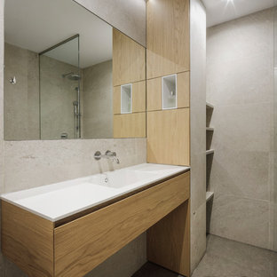 Ejemplo de cuarto de baño con ducha, minimalista, con encimera de cuarzo compacto, encimeras blancas, puertas de armario de madera oscura, baldosas y/o azulejos grises, baldosas y/o azulejos de porcelana, armarios con paneles lisos, ducha esquinera, paredes grises, suelo de cemento, lavabo integrado, suelo gris y ducha abierta
