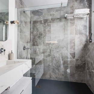 Foto de cuarto de baño con ducha, industrial, pequeño, con sanitario de pared, baldosas y/o azulejos grises, baldosas y/o azulejos de mármol, paredes grises, suelo de baldosas de cerámica, lavabo de seno grande, encimera de cuarzo compacto, suelo negro, ducha abierta, armarios con paneles lisos, puertas de armario blancas, ducha empotrada y encimeras beige