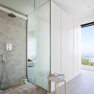 Modelo de cuarto de baño con ducha, moderno, de tamaño medio, con ducha abierta, paredes blancas, suelo de madera en tonos medios y ducha abierta