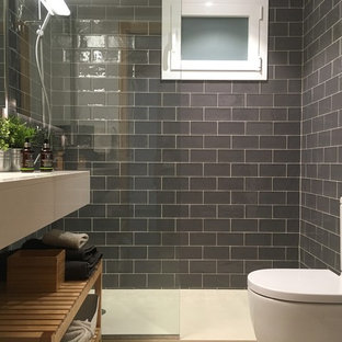 Exempel på ett litet klassiskt en-suite badrum, med en kantlös dusch, ett urinoar, grå kakel, tunnelbanekakel, vita väggar, terrazzogolv, ett undermonterad handfat och bänkskiva i akrylsten