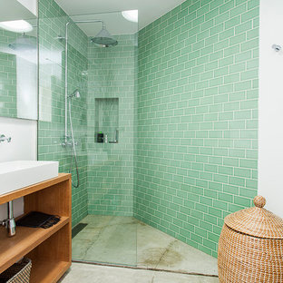 Foto de cuarto de baño contemporáneo con armarios abiertos, puertas de armario de madera oscura, ducha esquinera, baldosas y/o azulejos verdes, paredes blancas, suelo de cemento, lavabo sobreencimera, encimera de madera, suelo gris, ducha abierta y encimeras beige