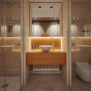 Imagen de cuarto de baño con ducha, actual, de tamaño medio, con armarios con paneles lisos, puertas de armario de madera oscura, ducha empotrada, baldosas y/o azulejos beige, baldosas y/o azulejos de porcelana, suelo de baldosas de porcelana, lavabo sobreencimera, encimera de madera, suelo beige, ducha con puerta con bisagras y encimeras beige