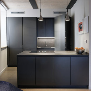 Esempio di una cucina design di medie dimensioni con top in laminato, parquet chiaro, pavimento beige, lavello sottopiano, ante lisce, ante nere, paraspruzzi grigio, elettrodomestici da incasso, penisola e top nero