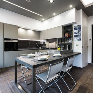 Esempio di una cucina contemporanea con ante lisce, ante grigie, paraspruzzi nero, elettrodomestici neri, parquet scuro, top nero, lavello sottopiano, penisola e pavimento marrone