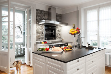 Immagine di una cucina classica con ante con bugna sagomata, ante bianche e paraspruzzi grigio