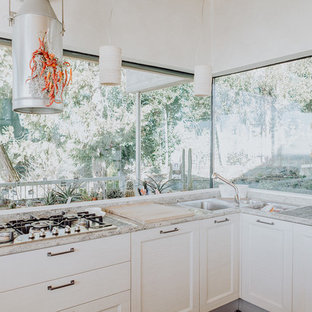 Idee per una cucina minimal con lavello a tripla vasca, ante in stile shaker, ante bianche, paraspruzzi a finestra e top grigio