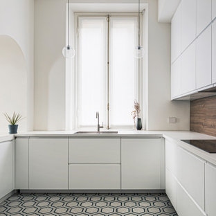 Immagine di una cucina ad U contemporanea con lavello sottopiano, ante lisce, ante bianche, pavimento in cementine, pavimento multicolore e top bianco