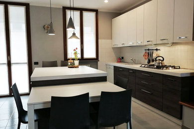 Immagine di una grande cucina minimalista con lavello a doppia vasca, ante lisce, ante in legno chiaro, top in laminato, elettrodomestici in acciaio inossidabile, pavimento in marmo, 2 o più isole, pavimento beige e top bianco