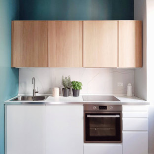 Idee per una piccola cucina lineare minimal con lavello da incasso, ante lisce, ante bianche, paraspruzzi grigio, elettrodomestici in acciaio inossidabile, parquet chiaro, nessuna isola, pavimento beige e top bianco