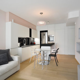 Esempio di una piccola cucina minimal con paraspruzzi nero, parquet chiaro, penisola, top nero, ante lisce, ante bianche, elettrodomestici in acciaio inossidabile, pavimento beige e lavello a tripla vasca