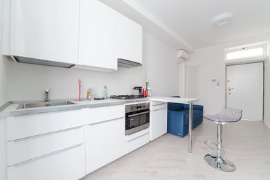 Esempio di una piccola cucina moderna con paraspruzzi bianco, pavimento in gres porcellanato, lavello da incasso e ante bianche