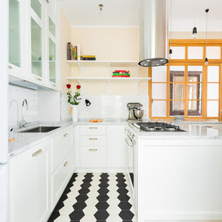 Immagine di una cucina ad U tradizionale con ante in stile shaker, ante bianche, lavello sottopiano, paraspruzzi bianco, paraspruzzi con piastrelle diamantate, penisola, pavimento nero e top grigio
