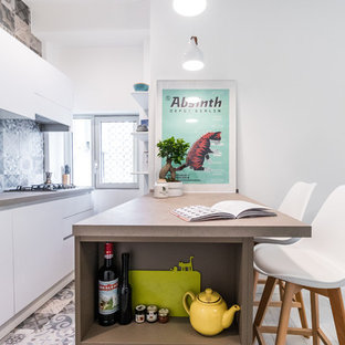 Foto di una cucina nordica con lavello sottopiano, ante lisce, ante bianche, paraspruzzi blu, elettrodomestici da incasso, penisola, pavimento blu e top beige