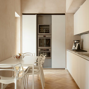 Esempio di una cucina lineare moderna chiusa e di medie dimensioni con ante lisce, nessuna isola, lavello integrato, ante beige, paraspruzzi beige, elettrodomestici in acciaio inossidabile, parquet chiaro, pavimento beige e top beige