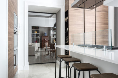 Foto di una cucina minimalista di medie dimensioni e chiusa con lavello integrato, ante lisce, ante in legno chiaro, top in laminato, paraspruzzi con lastra di vetro, elettrodomestici in acciaio inossidabile, pavimento in marmo e pavimento bianco