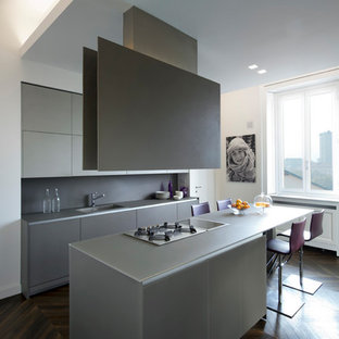 Ispirazione per una cucina minimalista di medie dimensioni con ante lisce, ante grigie, paraspruzzi grigio e isola