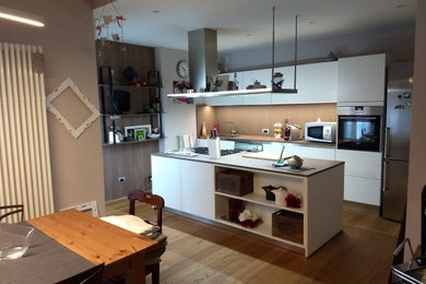 Foto di una cucina minimalista di medie dimensioni con parquet chiaro e pavimento beige