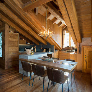 Immagine di una cucina abitabile stile rurale con pavimento in legno massello medio e penisola