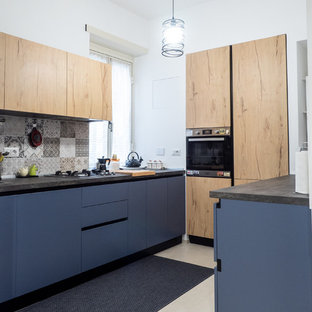 Foto di una cucina design con ante lisce, ante blu, paraspruzzi multicolore, elettrodomestici neri, pavimento beige e top grigio