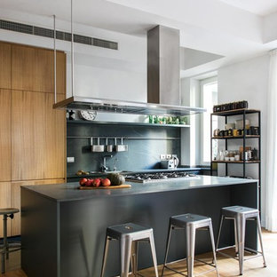 Immagine di una cucina industriale con ante lisce, ante marroni, paraspruzzi grigio, pavimento in legno massello medio, pavimento marrone e top grigio