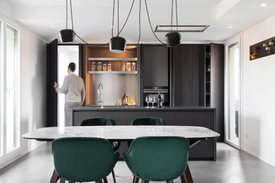Immagine di una cucina design di medie dimensioni con top in laminato, pavimento in cemento, pavimento grigio, top nero, ante lisce, ante nere e paraspruzzi a effetto metallico