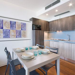 Immagine di una cucina moderna di medie dimensioni con lavello da incasso, ante lisce, ante in legno scuro, elettrodomestici da incasso, pavimento in legno massello medio, nessuna isola, pavimento marrone e top grigio
