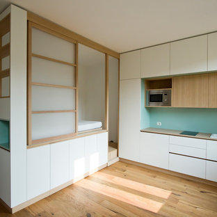 Esempio di una piccola cucina nordica con parquet chiaro, lavello da incasso, ante lisce, ante bianche, paraspruzzi verde, elettrodomestici in acciaio inossidabile, nessuna isola e top beige