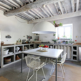 Foto di una cucina mediterranea con lavello da incasso, nessun'anta, ante grigie, top in cemento, paraspruzzi bianco, elettrodomestici in acciaio inossidabile, pavimento in cemento, nessuna isola, pavimento grigio e top grigio