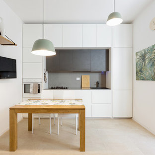 Esempio di una piccola cucina minimal con ante lisce, ante bianche, paraspruzzi grigio, nessuna isola, lavello da incasso, elettrodomestici da incasso e pavimento beige