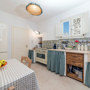 Foto di una cucina mediterranea con lavello integrato, ante lisce, paraspruzzi multicolore, paraspruzzi con piastrelle di cemento, elettrodomestici colorati, pavimento in pietra calcarea, nessuna isola, pavimento beige e top beige